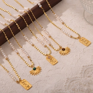 Elegant gold pearl necklace with tiger eye stone pendant and vintage engraved metal charms