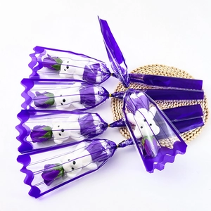 Macro detail of five purple soap rose bouquets with white bears in purple lace wrapping