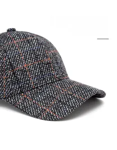 Macro detail of plaid tweed baseball cap showing textured fabric and curved brim