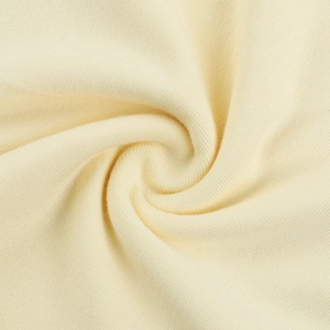 Gros plan du tissu en maille côtelée crème avec texture élastique douce et plis en spirale