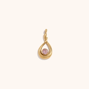 Macro detail of tear drop shaped 18K gold plated pendant with a sparkling pink gemstone