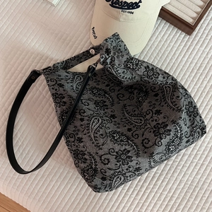 Detail view of cotton tote bag with paisley floral print and leather shoulder strap