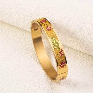 Detail of gold-plated stainless steel bangle featuring red flower and green leaf enamel