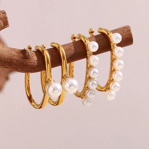 Elegant 18K gold plated pearl hoop earrings displayed on a natural wooden branch