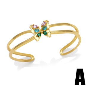 Golden butterfly bangle with colorful zircon stones on a minimalist white background