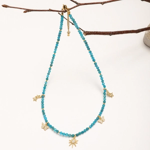 Close-up of bohemian blue beaded necklace with gold butterfly and star pendants