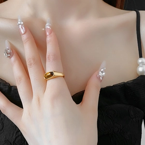 Detailed close-up of a gold-plated oval tiger eye ring worn on a woman's finger