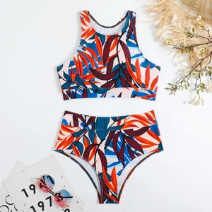 Flat lay of a two-piece tropical plant print swimsuit with high waist bottoms and tank top