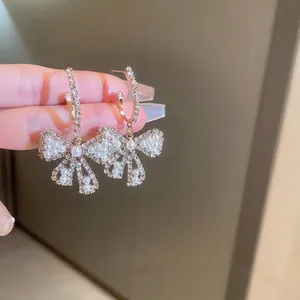 Elegant gold bow earrings with crystal diamonds and hanging pearls for women