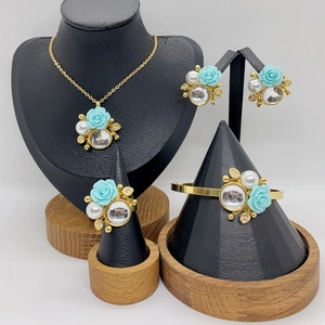 Golden jewelry set with blue rose motifs and pearls including necklace earrings and ring