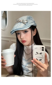 Detail of blue denim beret with silver bow and rhinestone on a young female model