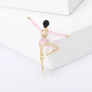Elegant gold ballet dancer brooch with pink enamel on a white geometric display