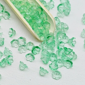 Detailed close-up of light green lily of the valley glass flower beads for DIY jewelry