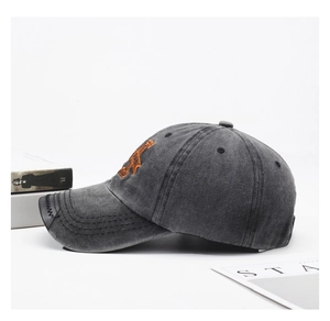 Dettaglio cappellino baseball grigio scuro lavato con ricamo arancione e cuciture visiera