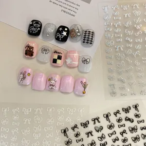 Macro detail of various bow nail stickers and decorative nail art tips on a cream background