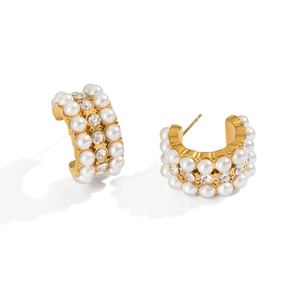 Dettaglio di orecchini a C placcati oro 18K con perle e cristalli su sfondo bianco