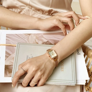 Rose gold square watch with Milanese mesh strap on wrist for a vintage aesthetic style
