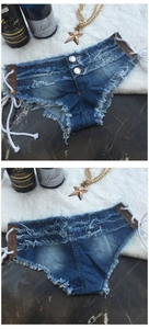 Dettaglio di pantaloncini di denim blu con lacci laterali e orli a taglio vivo