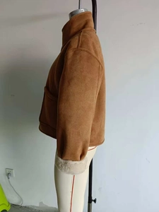 Detail of a brown suede jacket featuring a warm plush lining and stylish folded cuffs