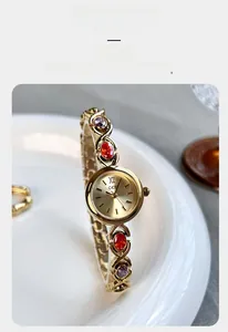 Détail de la montre luxe pour femme avec bracelet chaîne dorée et pierres gemmes