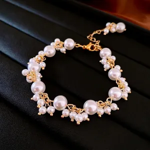 Elegant French vintage gold bracelet featuring irregular pearls on black leather background