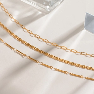 Three gold stainless steel necklaces with O-link, rope, and bamboo chain styles