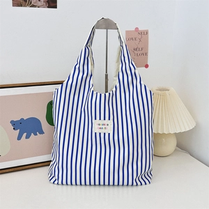 Détail du sac cabas en toile à rayures bleues et blanches avec écusson sozakka beauté