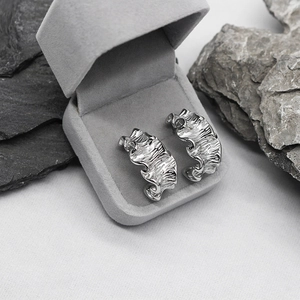 Silver irregular wavy textured earrings in a velvet gift box on dark stone