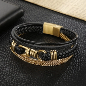 Macro detail of multi-layer black braided leather bracelet with golden magnetic buckle