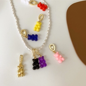 Dettaglio di ciondoli a forma di orsetto in resina colorata e metallo dorato con perle