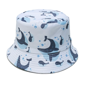 Detailed top view of a white cotton bucket hat featuring blue whale and ocean patterns