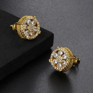 Detailed close-up of gold hip hop stud earrings with micro-paved sparkling cubic zirconia