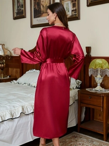 Detailed back view of a long burgundy satin robe featuring a sleek waist tie design