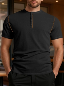 Close-up of black waffle knit shirt with orange contrast stitching and button placket