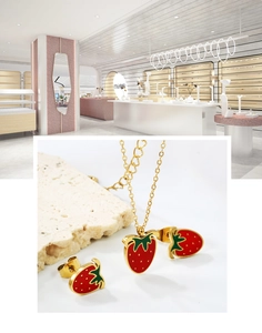 Detailed view of gold stainless steel strawberry jewelry set with red enamel pendant