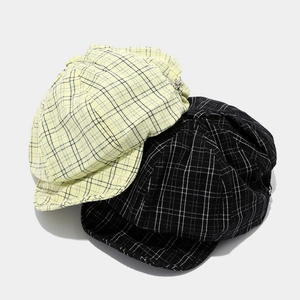 Checkered newsboy caps in yellow and black patterns with elegant metal button detail