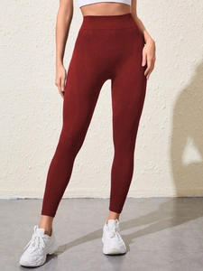 Détail macro du legging de yoga sans couture bordeaux montrant la texture côtelée et la taille