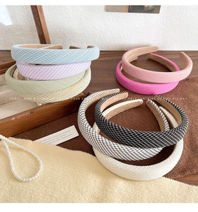 Macro shot of assorted colorful tweed padded headbands on rustic wooden tray background