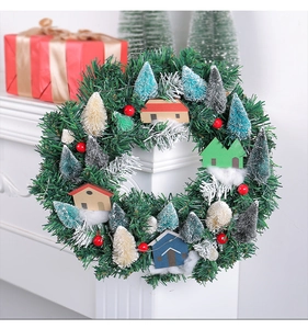 Detail of Christmas wreath with miniature houses and berries on a white mantelpiece