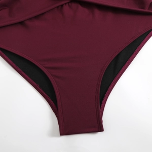 Detail view of burgundy swim bottom featuring high-stretch fabric and reinforced double stitching