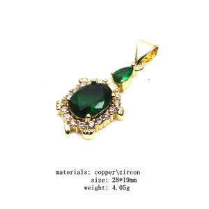 Detailed view of gold turtle pendant with green zircon inlay and size parameters