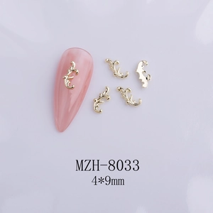 Macro shot of 4x9mm gold bow alloy nail art charms with baroque scroll patterns