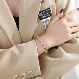 Chic silver knot link chain bracelet for women shown on a model wearing a beige blazer
