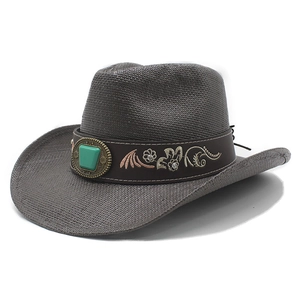 Détail d'un chapeau de cowboy en paille marron avec broderie florale et pierre turquoise