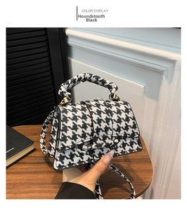 Detail of fabric texture on black houndstooth mini crossbody bag with gold hardware