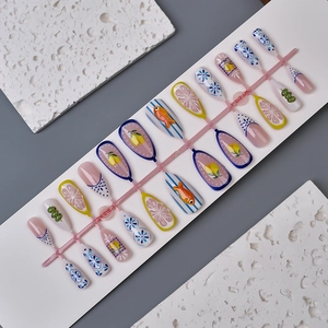 Detail of 3D porcelain nails with fish and lemon patterns on a white display board