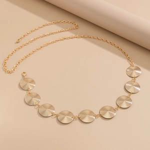 Detailed view of golden textured round metal discs on a beach style body waist chain
