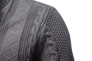 Dettaglio di trame a treccia e rombi grigio scuro su un cardigan in maglia da uomo