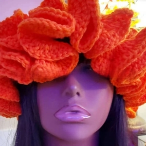 Detailed view of layered crochet ruffles on a vibrant orange knit hat for women