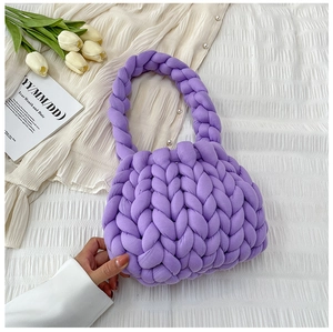 Detailed close-up of a handmade thick-knit purple handbag with soft woven texture